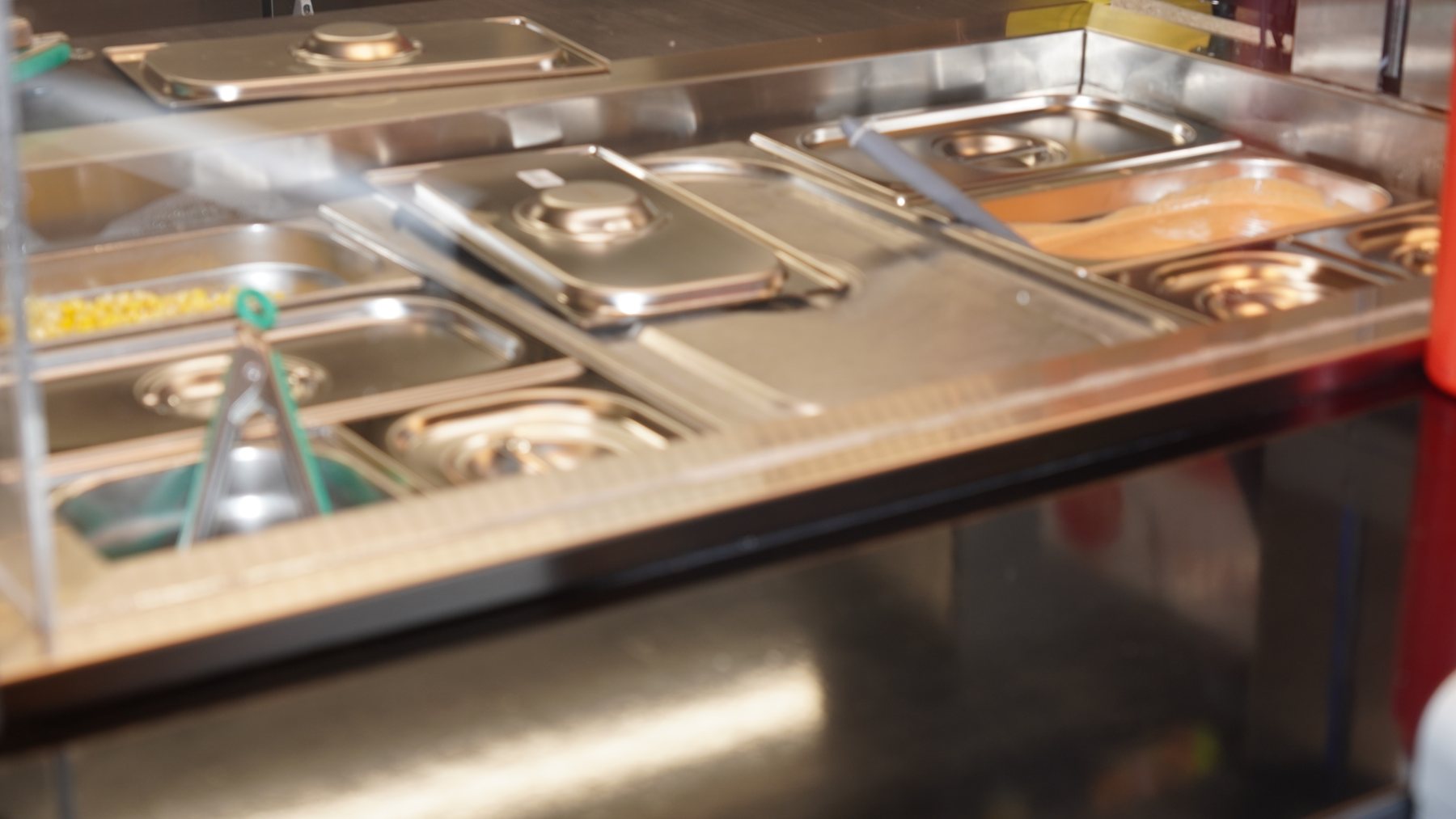 Grillstasjon og varmebord med kjøtt og tilbehør på kjøkkenet hos Favoritten — kebab og grill i Drammen